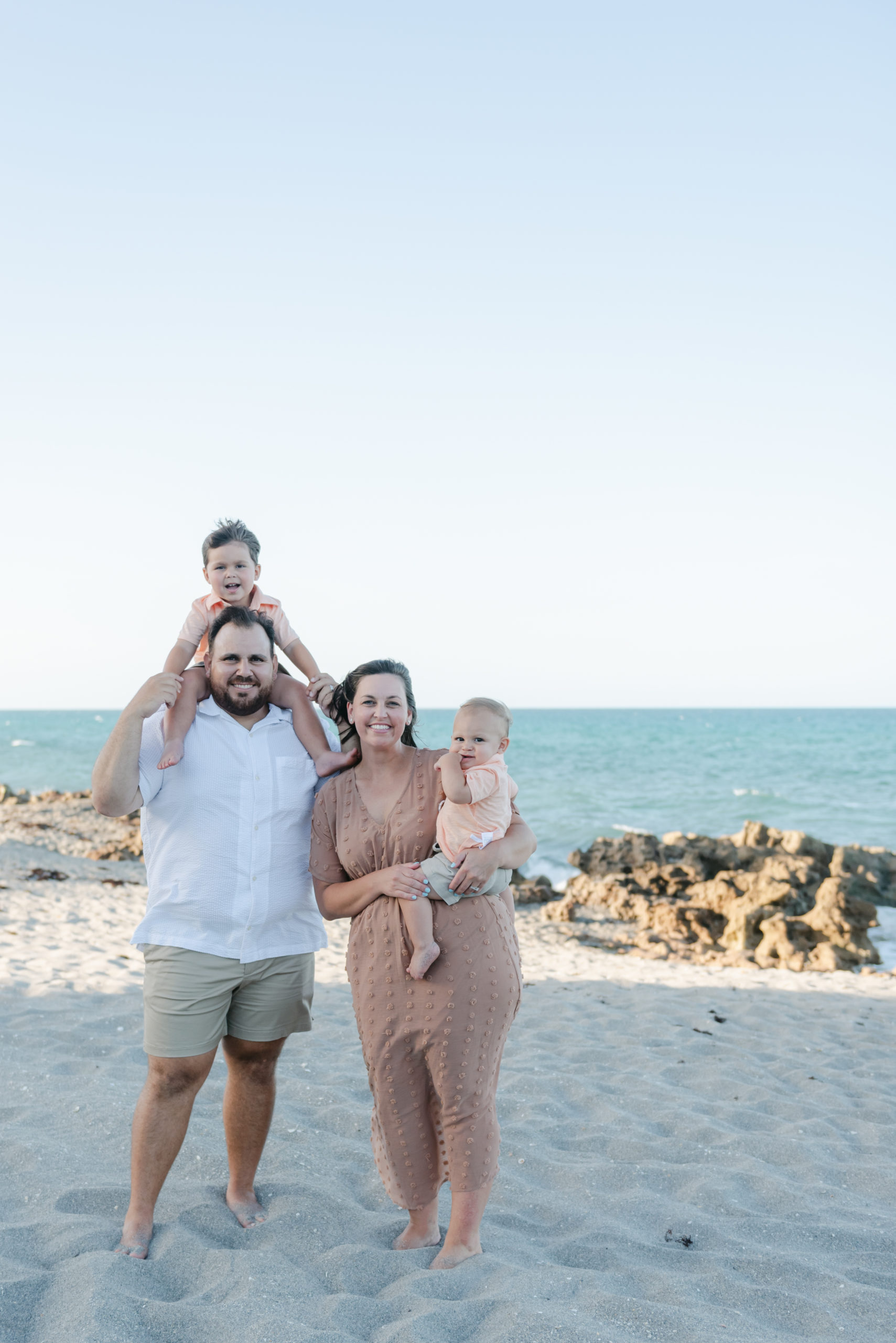 Mom holding one son, dad has other son on shoulders