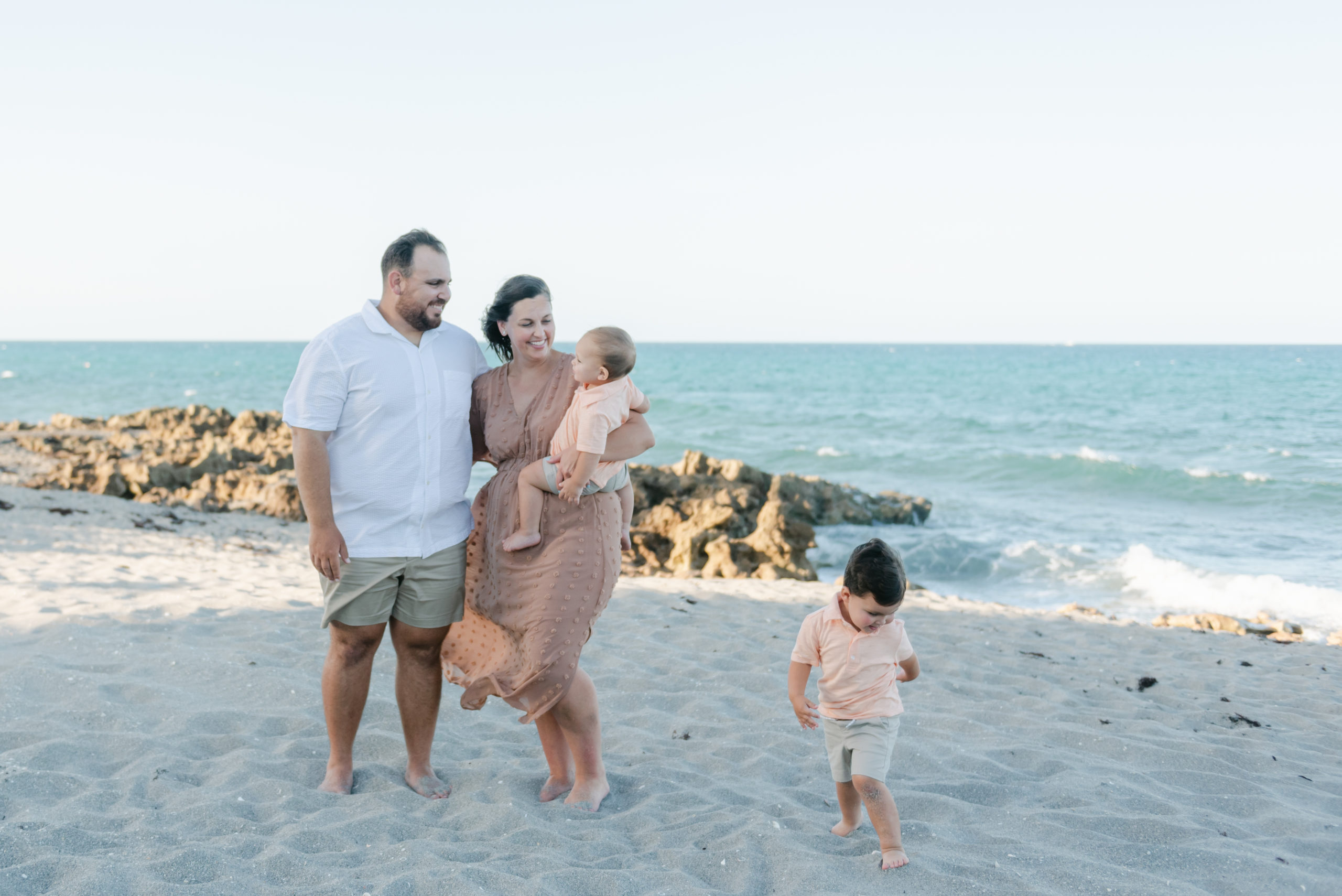 Mom and dad with baby, toddler running around