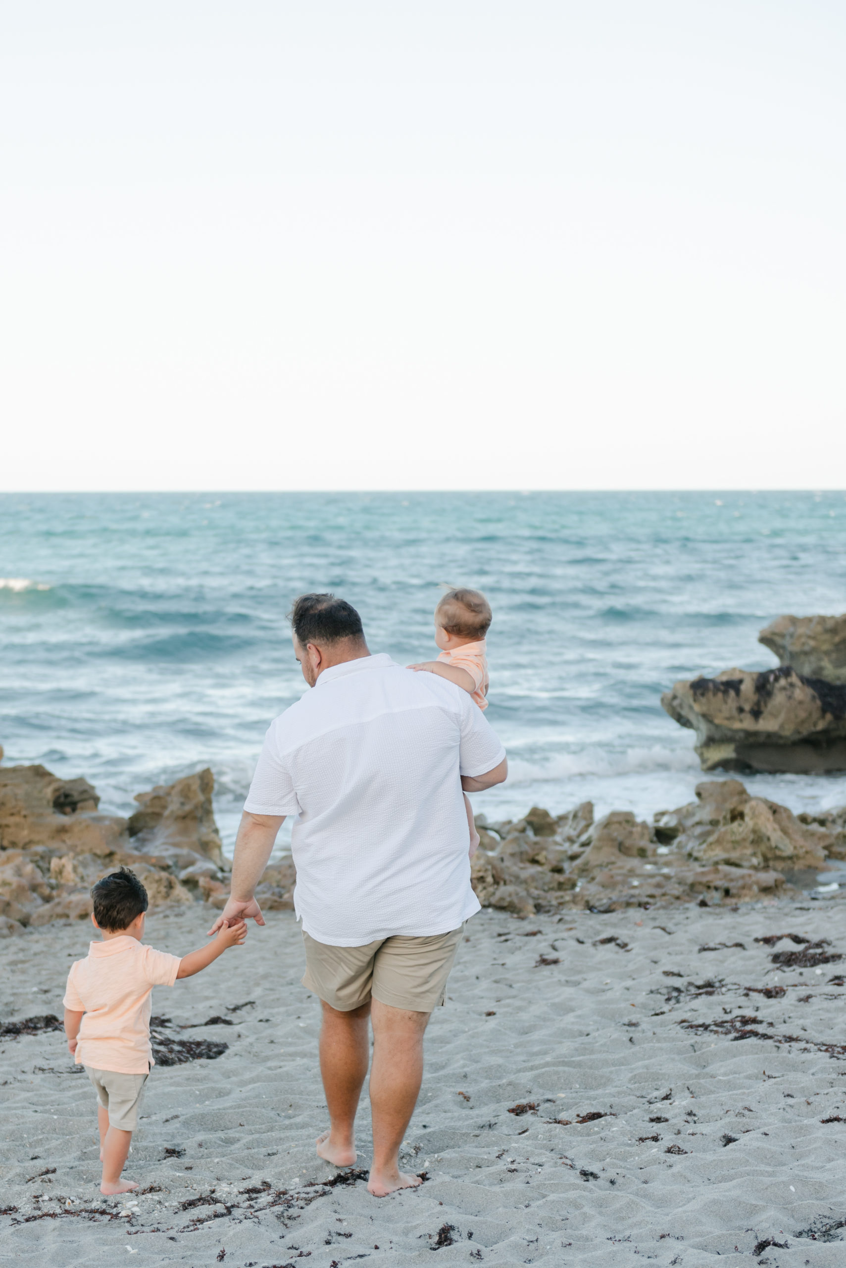 Dad walking towards the water with his sons