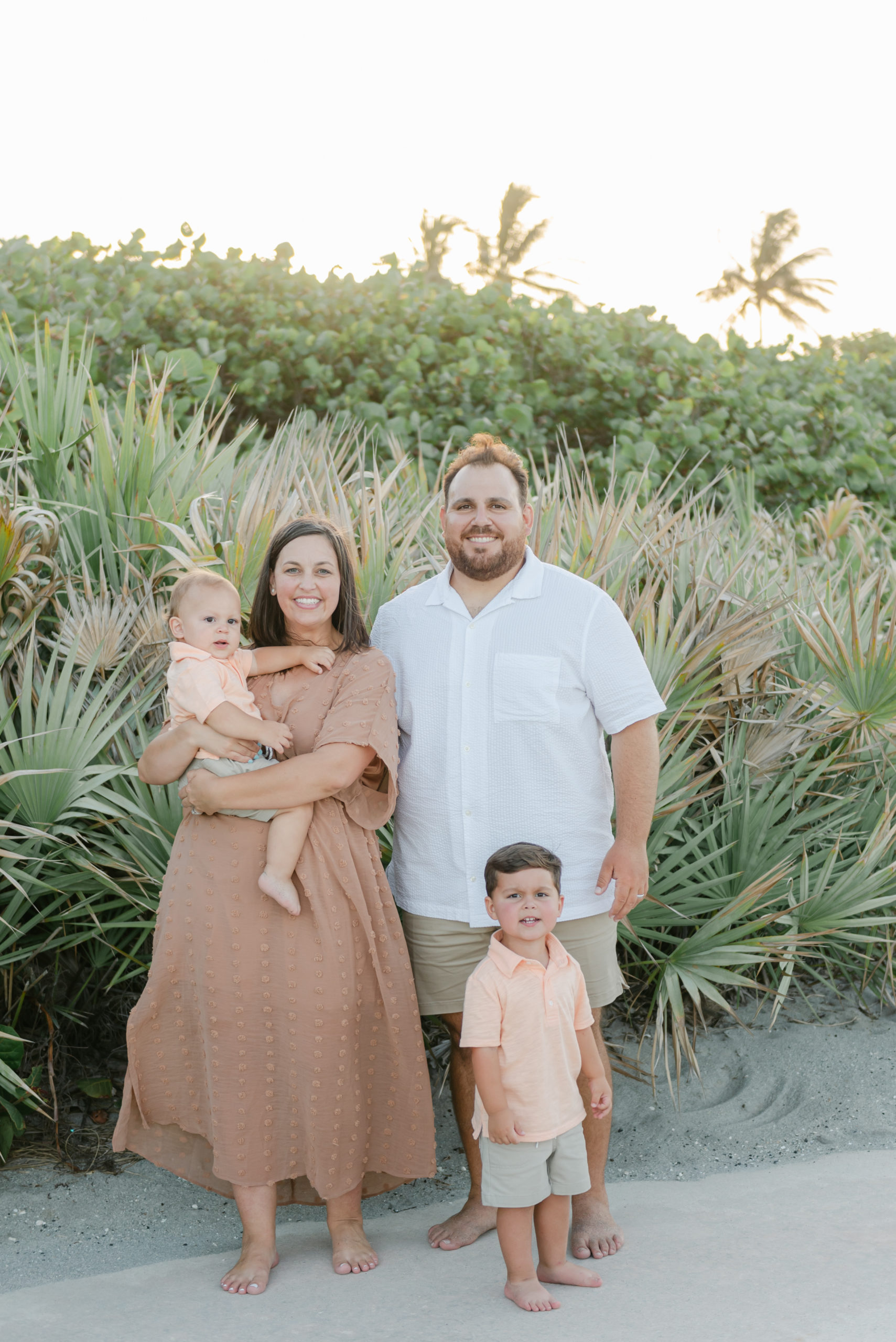 Family smiling in front of palm trees