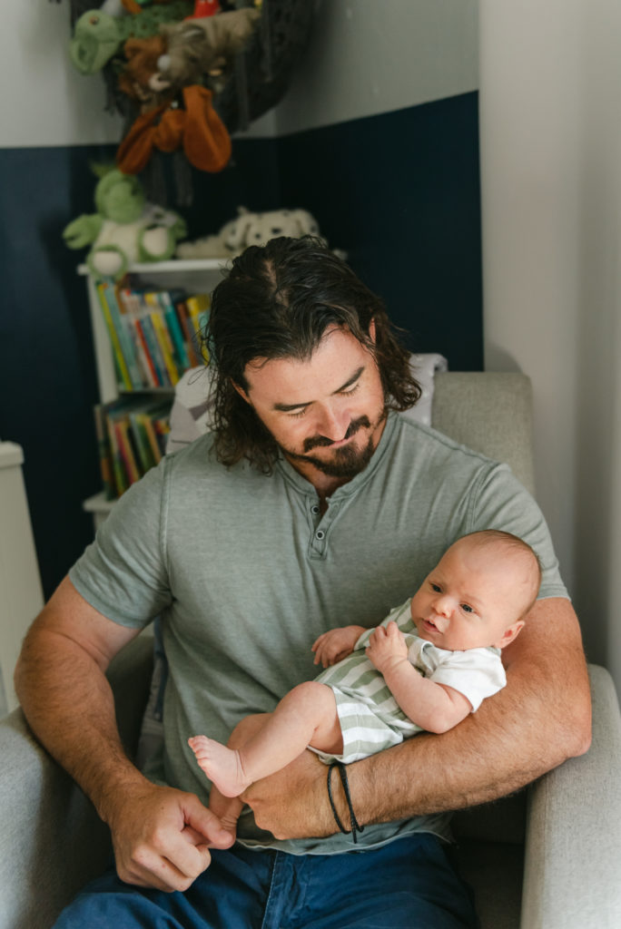 Dad holding baby sitting in chair