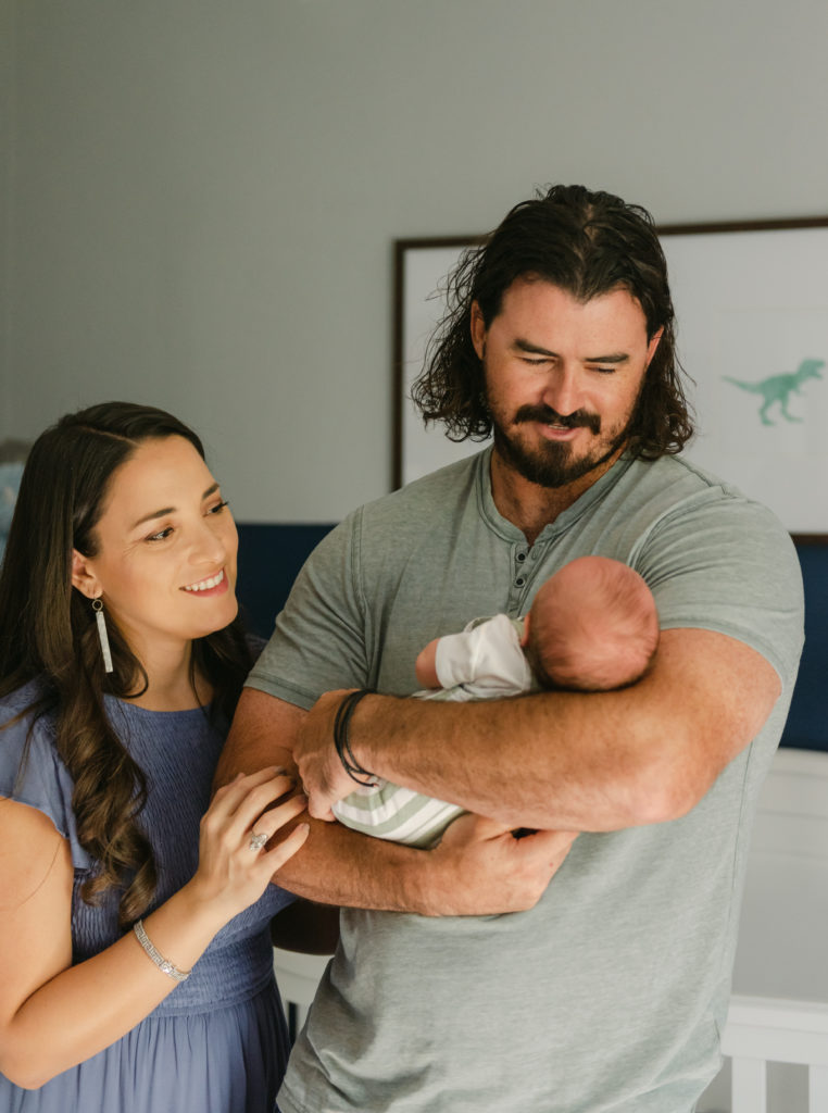 Dad holding baby, mom looking on