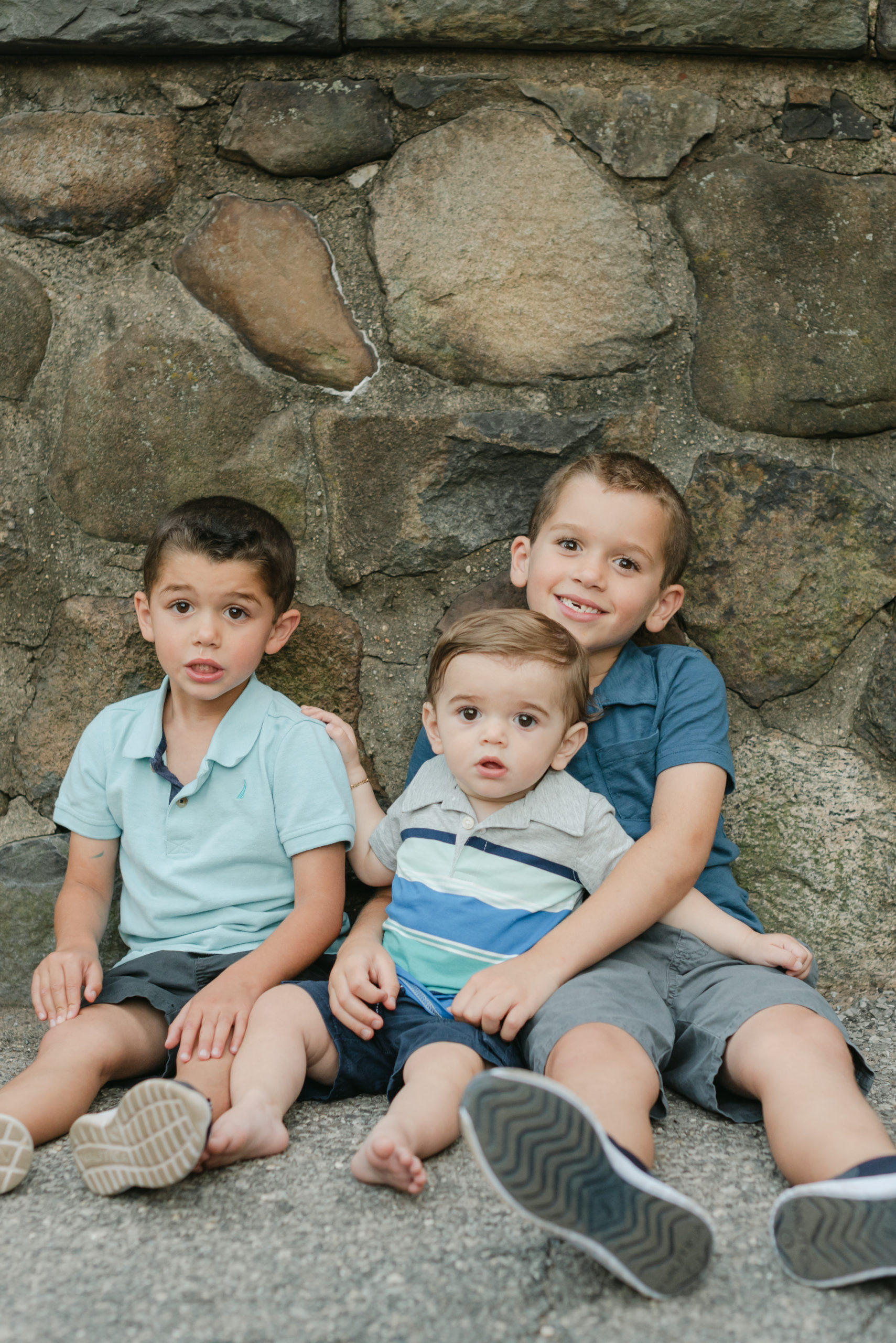 Three boys in front of stone wall