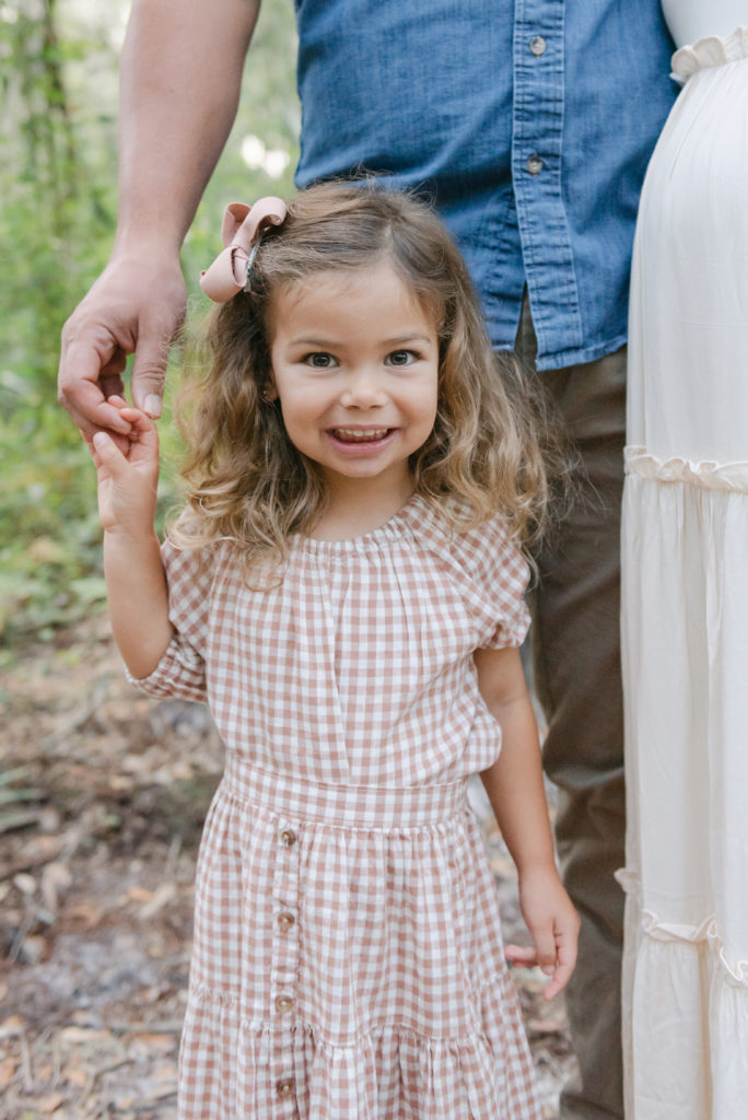 Older daughter holding mom's hand smiling