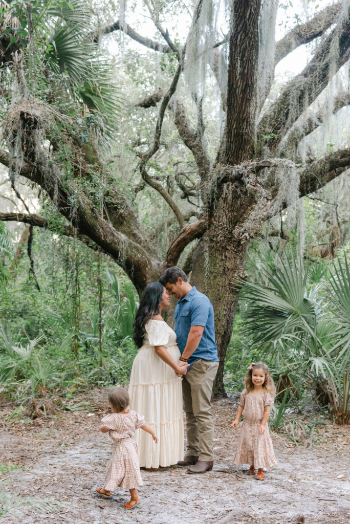 Mom and dad together, daughters running around 