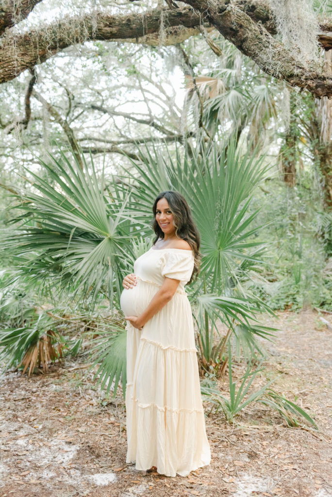 Mom holding belly, smiling