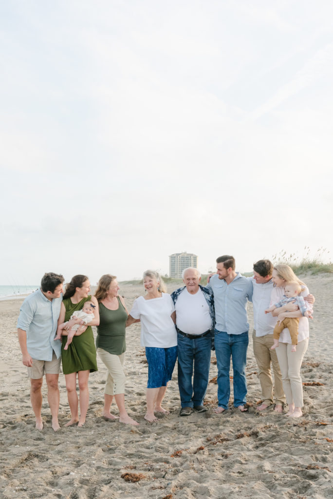 Grandchildren looking at their grandparents on the beach by Palm Beach family photographer