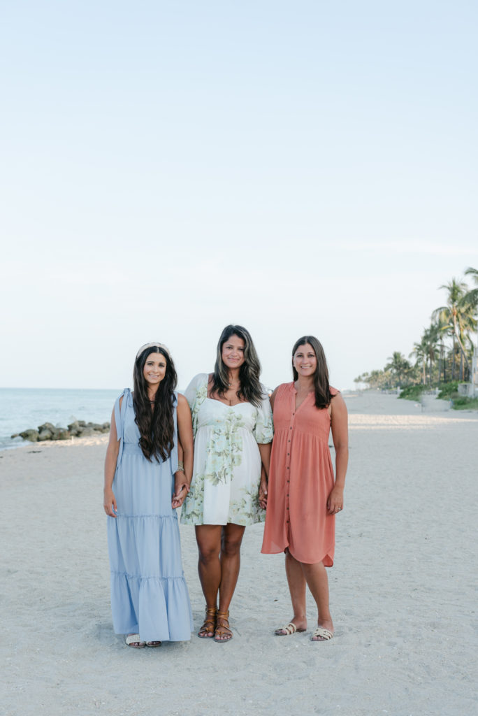 Three sisters holding hands on the beach by Palm Beach family photographer