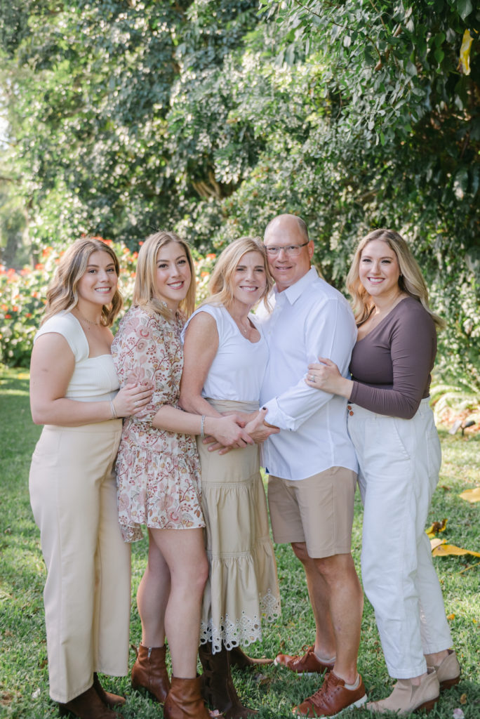 Three sisters surrounded mom and dad holding hands by Palm Beach family photographer
