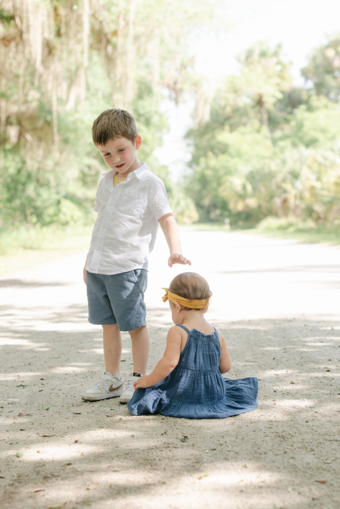 Daughter sitting on ground, son standing by Jupiter photographer