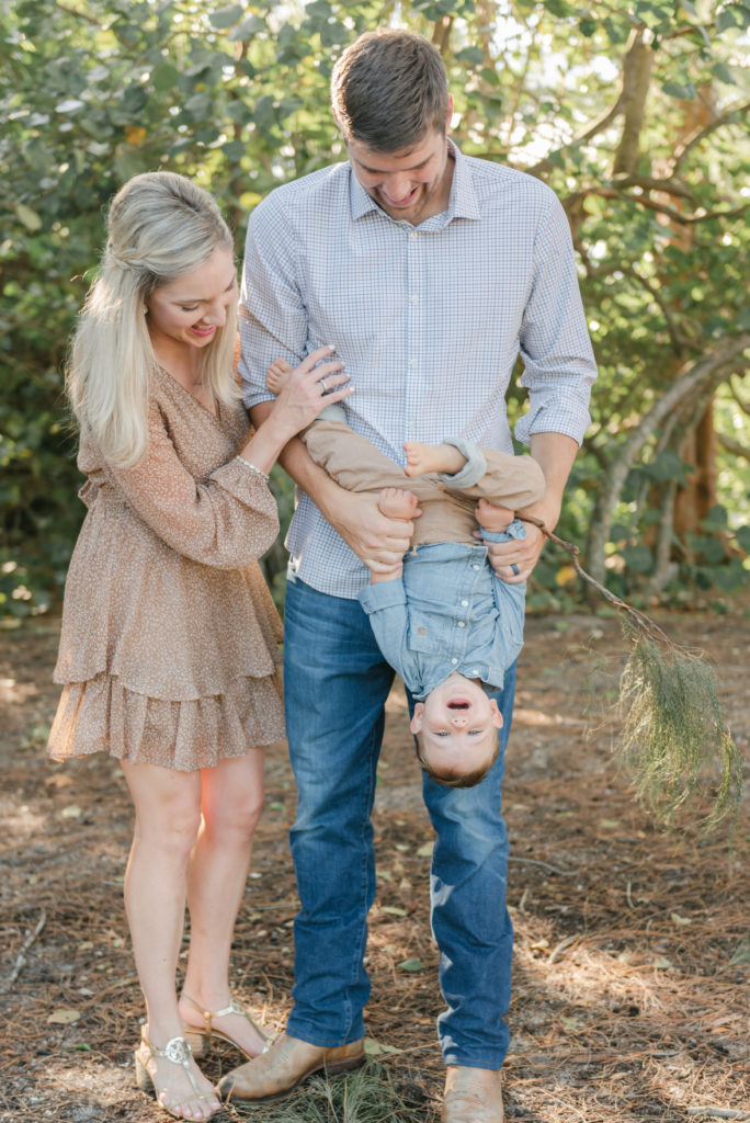 Dad tilting son upside down, mom holding on by Jupiter photographer