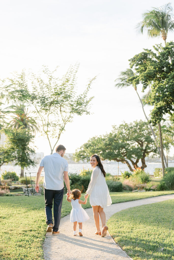 Mom, dad and daughter walking.  Mom looking back