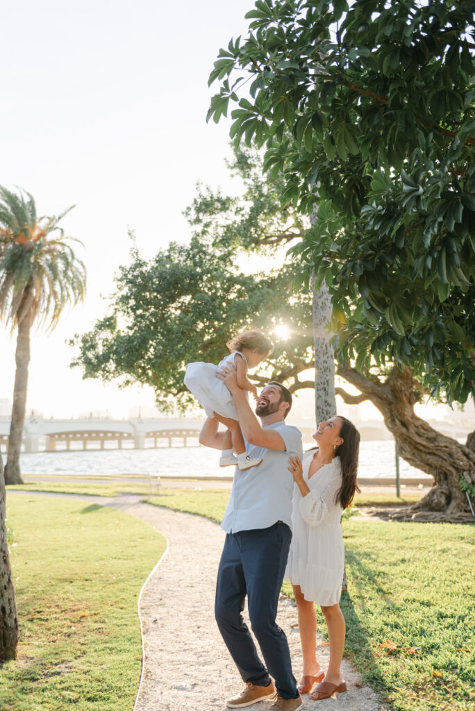 Dad lifting up daughter, mom behind dad