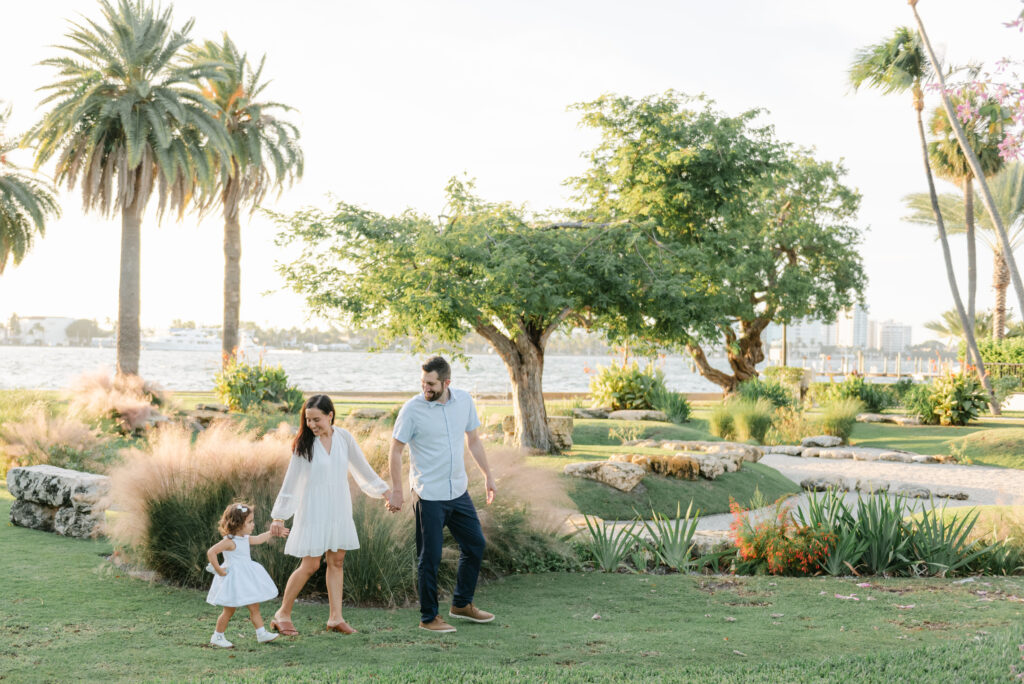 Mom dad and daughter walking by the garden