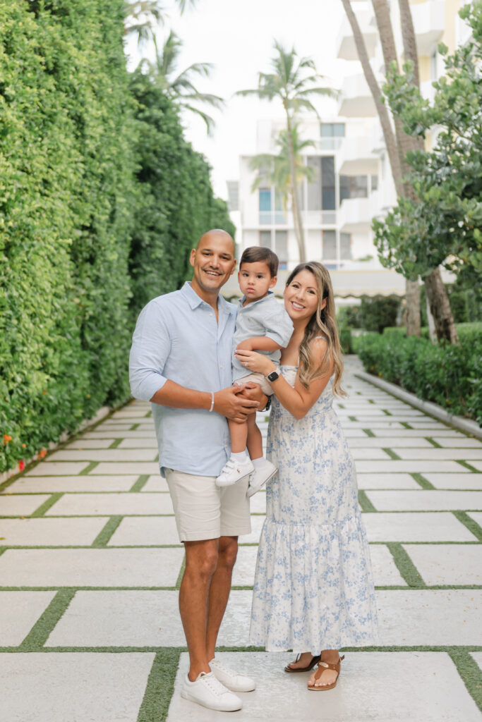 Mom and dad standing, holding son