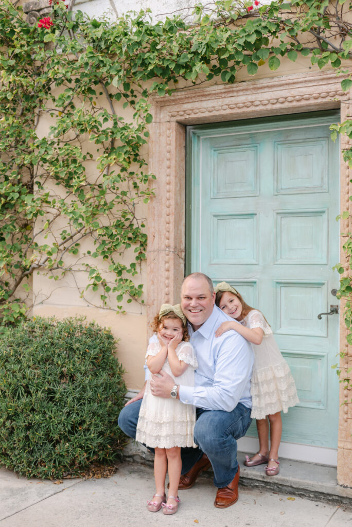 Dad crouching down with two daughters